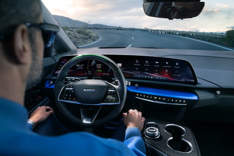 Front View of the 2026 OPTIQ-V Driving Through the Dusk Utilizing its Headlights | Cadillac of Jackson in Ridgeland MS